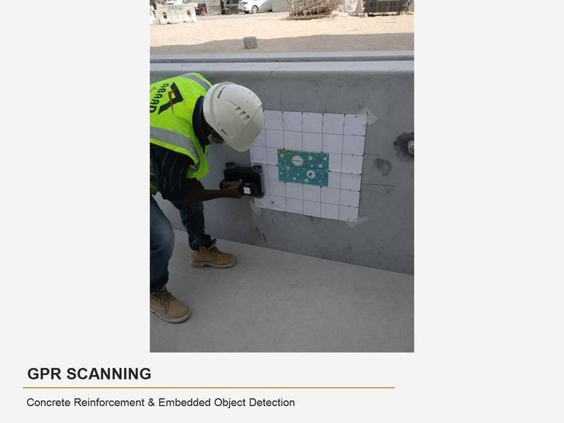 Abaad technician performing GPR scanning on a concrete wall with a calibration grid
