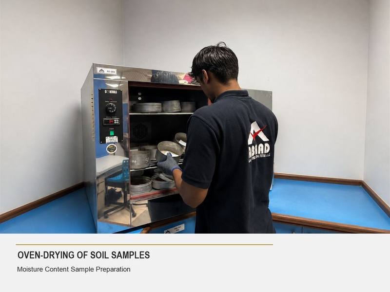 Abaad technician placing soil sample tins in a drying oven