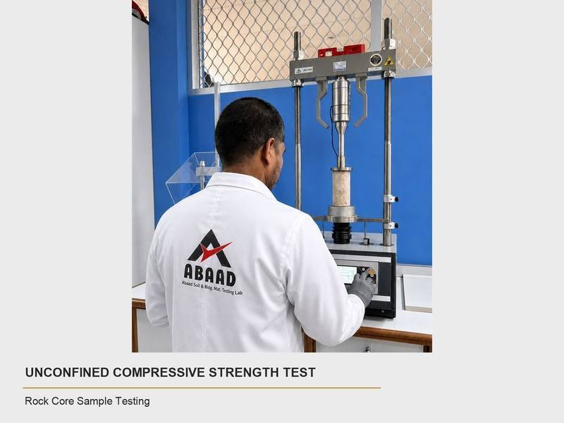 Abaad technician performing an unconfined compressive strength test on a rock core sample